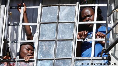 Residents in Kawangware, Nairobi, look out through barred windows at the protests.