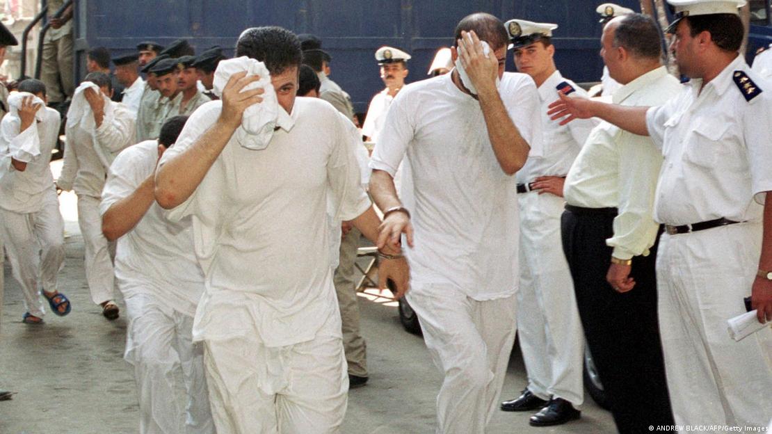 Egyptian men who have been accused of having gay sex cover their faces as they walk into a Cairo court 18 July 2000