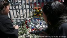 Women place flowers in front of a gate that has been converted into a makeshift memorial, outside a Mexican immigration detention center in Ciudad Juarez, Mexico, Tuesday, March 28, 2023, where a fire in a dormitory left more than three dozen migrants dead. President Andrés Manuel López Obrador said the fire was started by migrants in protest after learning they would be deported. (AP Photo/Christian Chavez)
