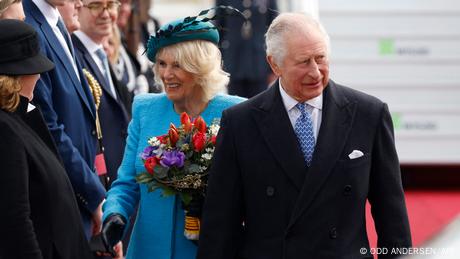 Charles und Camilla begrüßen eine Delegation am Flughafen