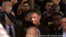 Brazil's former President Jair Bolsonaro greets supporters outside the Liberal Party's headquarters in Brasilia, Brazil, Thursday, March 30, 2023. Bolsonaro arrived back in Brazil on Thursday after a three-month stay in Florida. (AP Photo/Gustavo Moreno)