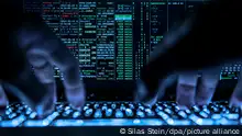 26.04.2019, Hessen, Rüsselsheim: LLUSTRATION - Ein Mann tippt auf der beleuchteten Tastatur eines Laptops, auf dem Bildschirm ist ein Hackerprogramm geöffnet. Foto: Silas Stein/