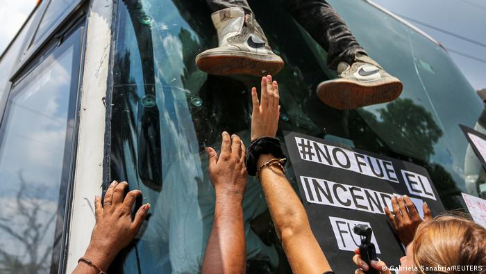 Un migrante detenido por las autoridades escapa de un ómnibus mientras activistas bloquean la entrada al centro de detención Siglo XXI, en Ciudad Juárez.