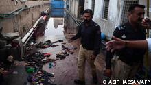 Police officers stands next to footwear of victims following a crowd crush that ocurred during a Ramadan alms distribution for people in need, in Karachi on March 31, 2023. - At least nine people were killed in a crowd crush in Pakistan's southern city of Karachi on March 31 as a Ramadan alms donation sparked a stampede in the inflation-hit nation, officials said. (Photo by Asif HASSAN / AFP)