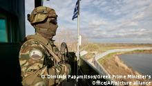 In this photo provided by the Greek Prime Minister's Office, a Greek soldier guards over a border wall near the town of Feres, along the Evros River which forms the frontier between Greece and Turkey, on Friday, March 31, 2023. Greece's Prime Minister Kyriakos Mitsotakis promised Friday to extend a wall across all of the country's land border with Turkey as he campaigned for the country's general election. (Dimitris Papamitsos/Greek Prime Minister's Office via AP)