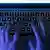 Fingers on a keyboard, in dark setting, symbolically associated with hackers