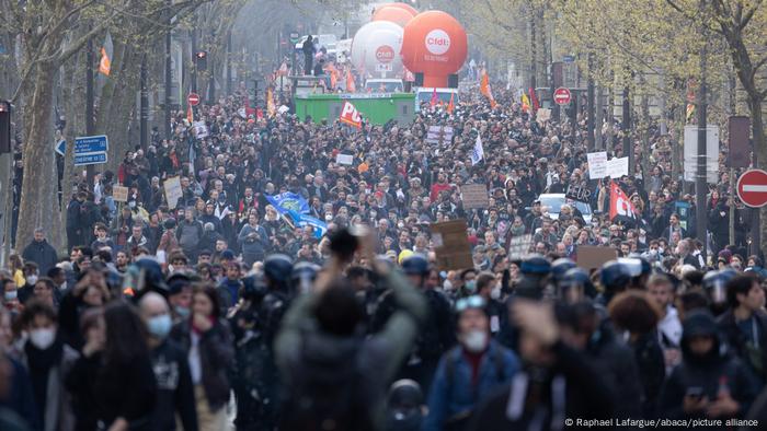 Menschenmassen strömen beim Protest gegen die Rentenreform durch eine Allee in Paris, Frankreich