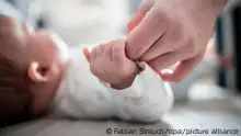 Ein Baby klammert sich an den Finger seiner Mutter. (Zu dpa «Geburtenrate pro Frau in Bayern 2021 gestiegen») +++ dpa-Bildfunk +++