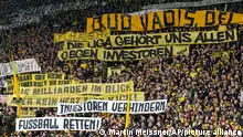 Fans hold up banners protesting against big investors in German soccer during the German Bundesliga soccer match between Borussia Dortmund and Union Berlin in Dortmund, Germany, Saturday, April 8, 2023. (AP Photo/Martin Meissner)