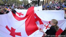 Demonstrators hold a giant Georgian flag during a rally organized by Georgian opposition parties in support of the country's membership in the European Union and to call to release former Georgian President Mikheil Saakashvili from the custody and transfer abroad for treatment in Tbilisi, Georgia, Sunday, April 9, 2023. (AP Photo/Zurab Tsertsvadze)