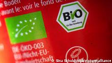 28.09.2022
Das EU-Bio-Logo, das deutsche staatliche Biosiegel und die Kennzeichnung „Vegan“ sind auf einer Lebensmittelverpackung.
