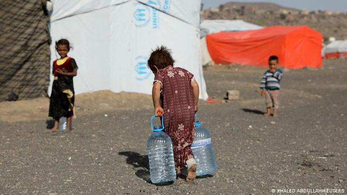 فتاة يمنية في أحد مخيمات اللجوء قرب صنعاء تحمل الماء الذي أضحى بالنسبة لعائلتها سلعة نادرة- مارس/ آذار 2022 فتاة يمنية في أحد مخيمات اللجوء قرب صنعاء تحمل الماء الذي أضحى بالنسبة لعائلتها سلعة نادرة- مارس/ آذار 2022