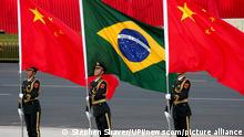 A Chinese military honor guard holds the national flags of China and Brazil during a welcoming ceremony for Brazilian President Jair Bolsonaro at the Great Hall of the People in Beijing on Friday, October 25, 2019. Bolsonaro told a forum that China and Brazil were born to walk together and the two governments are completely aligned in a way that reaches beyond our commercial and business relationship. Photo by Stephen Shaver/UPI Photo via Newscom picture alliance