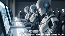 Generative AI image of group of robots sitting at table and working on laptops while looking at screen in modern office and using artificial intelligence ManuelRuiz_ID13614_413581_011 Copyright: xManuelxRuizx
