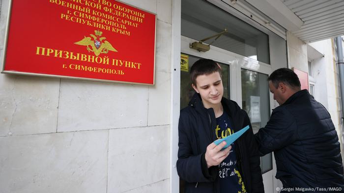 Ein junger Wehrpflichtiger der russischen Armee steht vor dem Eingang eines Einberufungsbüros in Simferopol