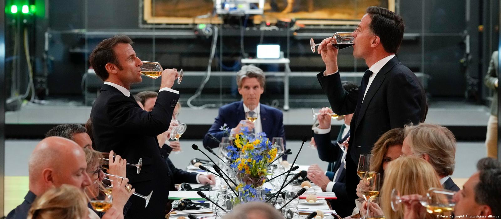 French President Emmanuel Macron, left, and Dutch Prime Minister Mark Rutte, right, propose a toast as they sit down for a working dinner in front of Rembrandt's Nightwatch at the Rijksmuseum in Amsterdam