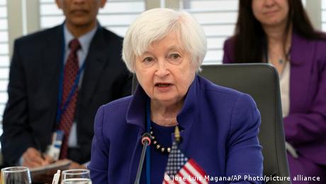 Auf dem Bild ist US-Finanzministerin Janet Yellen abgebildet. Sie sitzt auf einem Stuhl und spricht in ein Mikrofon. Im Hintergrund erkennt man zwei weitere Personen. (Quelle: Jose Luis Magana/AP Photo/picture alliance)