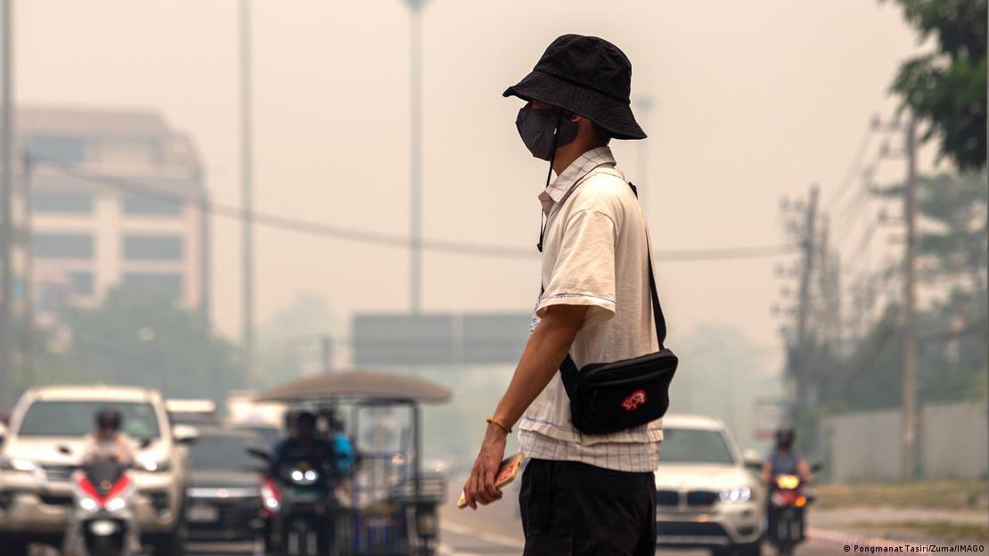 Un hombre con mascarilla camina por una calle en medio del smog en Chiang Mai, Tailandia