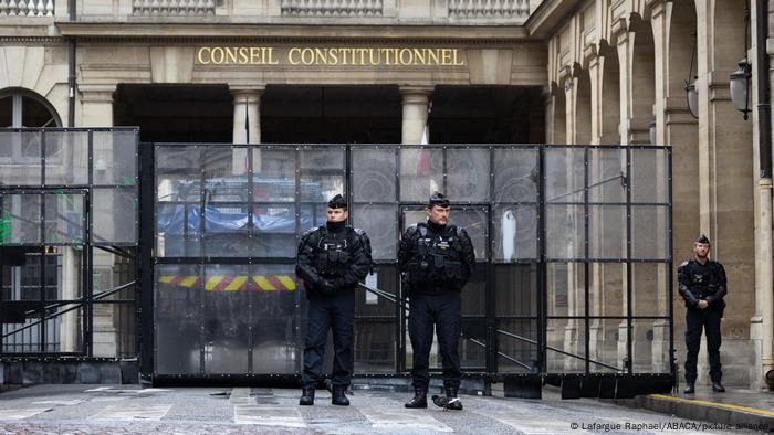 Mehrere bewaffnete Polizisten stehen vor dem Gebäude des französischen Verfassungsrats in Paris, Frankreich