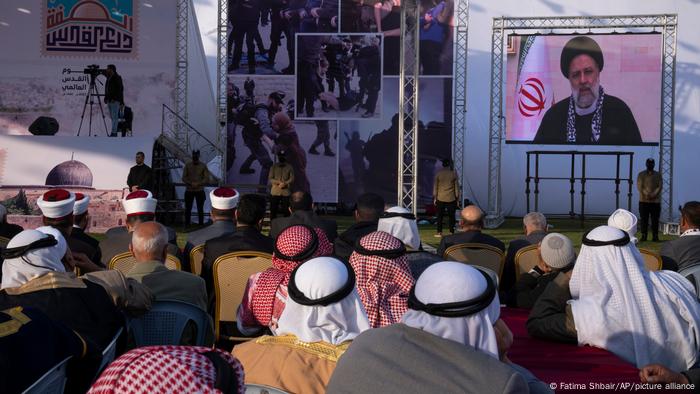 Der iranische Präsidenten Ebrahim Raisi auf einer Leinwand, davor palästinensische Zuschauer Der iranische Präsidenten Ebrahim Raisi auf einer Leinwand, davor palästinensische Zuschauer