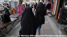 March 17, 2023. A veiled Iranian mother (L) and her young daughter who has not wearing mandatory headscarf, walk past vendors while shopping for celebrating Iranian New Year holidays, in northern Tehran, March 17, 2023. Iranians will be celebrating first day of spring as the beginning of new Year in Iranian calendar. (Photo by Morteza Nikoubazl/NurPhoto)