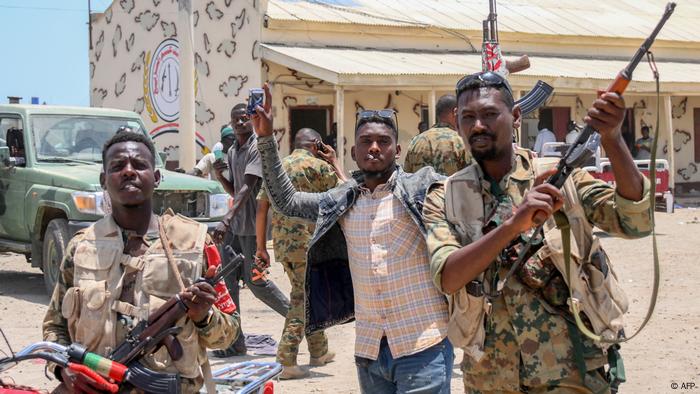 Soldaten der regulären sudanesischen Armee halten Waffen hoch 