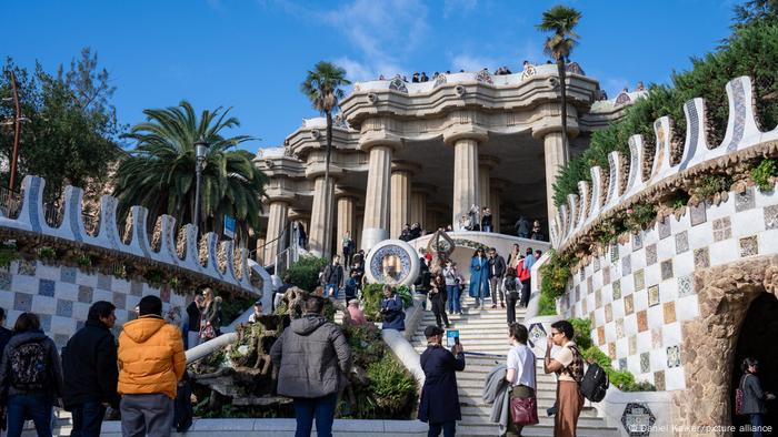 Touristen auf der Haupttreppe und Hippostila des Park Güell von Antoni Gaudí in Barcelona.