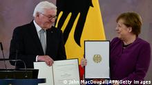 17/04/2023 *** German President Frank-Walter Steinmeier (L) awards the Order of Merit to former German Chancellor Angela Merkel at the Bellevue presidential palace in Berlin on April 17, 2023. (Photo by John MACDOUGALL / AFP) (Photo by JOHN MACDOUGALL/AFP via Getty Images)