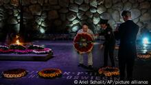 An elderly man places a wreath on a marker for the Auschwitz concentration camp in the Hall of Remembrance during the Holocaust Martyrs and Heroes Remembrance Day at the Yad Vashem Holocaust Museum in Jerusalem, Israel, Tuesday, April 18, 2023. (AP Photo/Ariel Schalit)