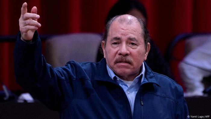 Nicaraguas Präsident Daniel Ortega steht mit erhobener rechter Hand und ausgestrecktem Zeigefinger und schaut Nicaraguas Präsident Daniel Ortega steht mit erhobener rechter Hand und ausgestrecktem Zeigefinger und schaut