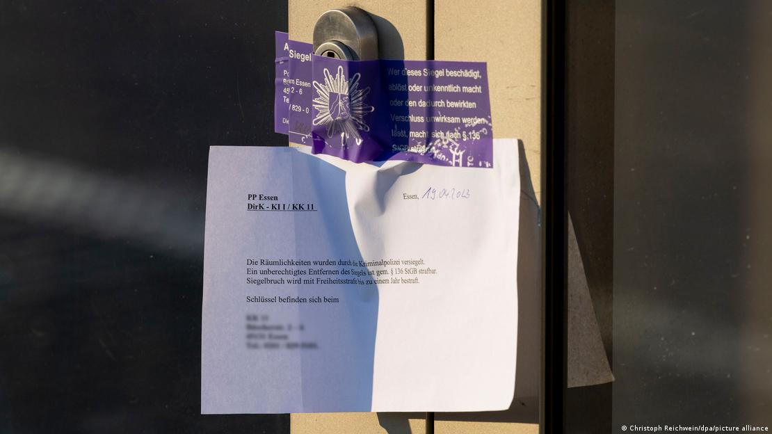 A close-up of the barred door to a fitness studio in Duisburg, Germany, with a note from police attached to the door, after four people were stabbed inside the building on April 18, 2023. 