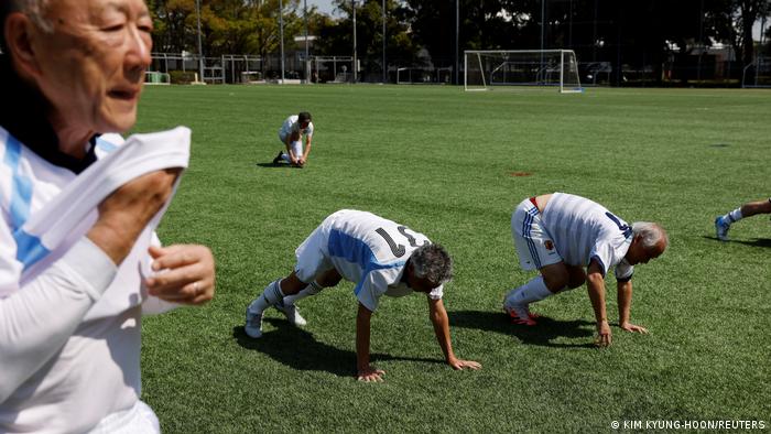 Personas mayores entrenan en una cancha.