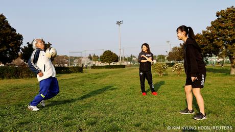 Mutsuhiko Nomura his daughter and granddaughter practicing soccer in a park