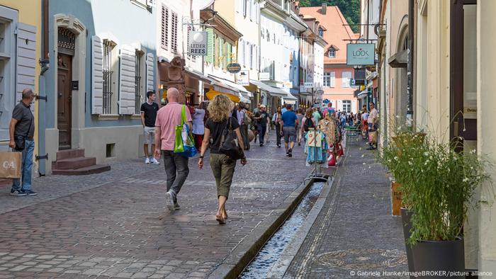 Freiburg: gente camina por las calles junto a pequeños canales de agua.