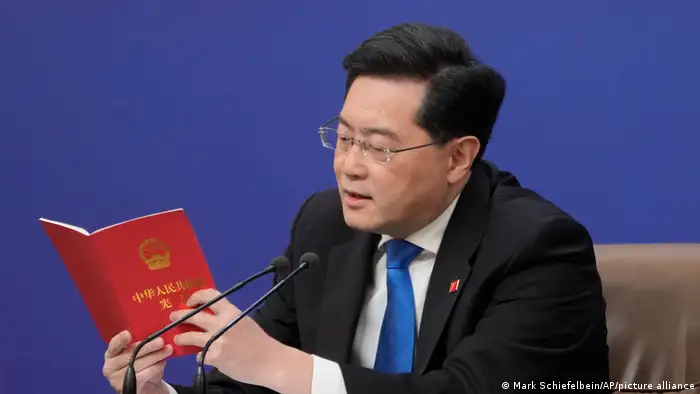 图为中国外长秦刚在2023年3月的全国人大会议期间举行的记者会上宣读了中国宪法