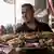 Υπάλληλος σερβίρει δίσκο με κρεατικά και άλλα φαγητά στο Κάιρο