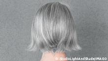 Woman with beautiful natural gray hair, from behind.