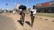 A man and a woman carrying luggage and a baby 