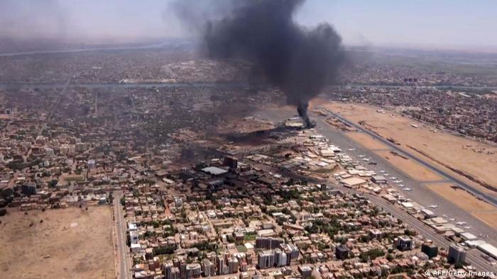 صورة مأخوذة من مقطع فيديو يظهر مشهدًا جويًا لدخان أسود يتصاعد فوق مطار الخرطوم الدولي 