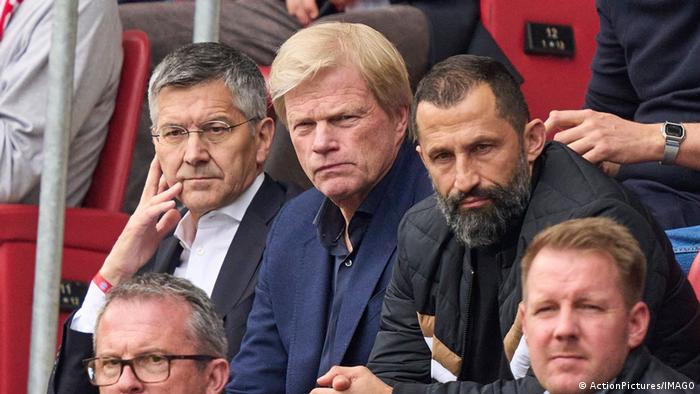 FCB-Präsident Herbert Hainer, Vorstandsvorsitzender Oliver Kahn und Sportdirektor Hasan Salihamidzic sitzen mit ernsten Mienen auf der Tribüne.