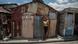 Una mujer con su hijo, ante una choza de latón. Una mujer con su hijo, ante una choza de latón.
