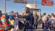 Migrants of various nationalities scuffle with the police near Tacna, Peru, on April 25, 2023. - Peru mobilized 200 police officers at its border with Chile in response to the arrival of dozens of undocumented Venezuelan and Colombian migrants who say they want to return to their home countries. Peru will ask Chile for official information on the supposed support of Chilean security forces for migrants to cross the binational border through illegal routes, according to a media outlet. (Photo by Javier Rumiche / AFP) (Photo by JAVIER RUMICHE/AFP via Getty Images)