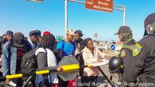 Migrants of various nationalities scuffle with the police near Tacna, Peru, on April 25, 2023. - Peru mobilized 200 police officers at its border with Chile in response to the arrival of dozens of undocumented Venezuelan and Colombian migrants who say they want to return to their home countries. Peru will ask Chile for official information on the supposed support of Chilean security forces for migrants to cross the binational border through illegal routes, according to a media outlet. (Photo by Javier Rumiche / AFP) (Photo by JAVIER RUMICHE/AFP via Getty Images)