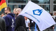 Ein Mitglied der Jungen Alternative, der Jugendorganisation der AfD, trägt auf einer Wahlkampfveranstaltung eine Fahne mit dem Logo der Organisation.