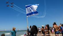 26/04/2023 *** TOPSHOT - People watch Israeli Air Force aircraft flyover a beach during an airshow in Tel Aviv on April 26, 2023, to mark the 75th anniversary of the State of Israel's creation. (Photo by Jack GUEZ / AFP) (Photo by JACK GUEZ/AFP via Getty Images)