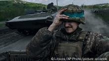 26/04/2023**A Ukrainian soldier holds his helmet as he rides an APC in Bakhmut, in the Donetsk region, Ukraine, Wednesday, April 26, 2023. (AP Photo/Libkos)
