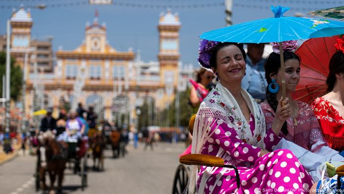 Un grupo de mujeres viajan en un carruaje protegidas bajo una sombrilla en la tradicional Feria de Abril en Sevilla, España, en un momento en que las típicas olas anuales de calor ya comienzan a asomarse. El servicio meteorológico nacional pronosticó una máxima de 38 grados centígrados para la primera semana de mayo en el sur del valle del Guadalquivir.