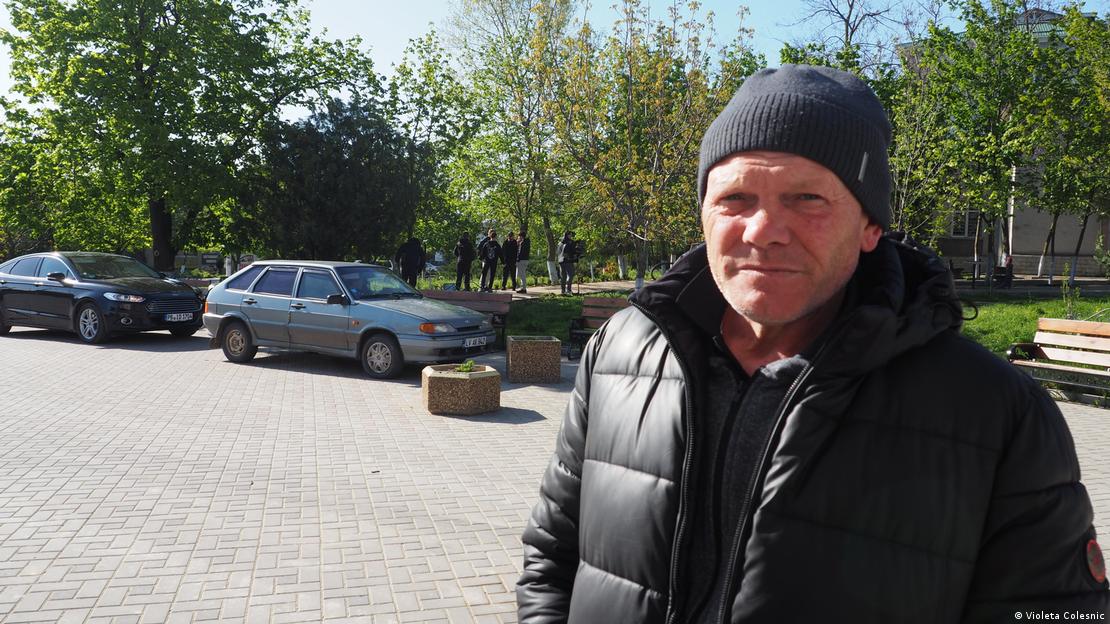 A middle-aged man in a black beanie hat and a black puffer jacket