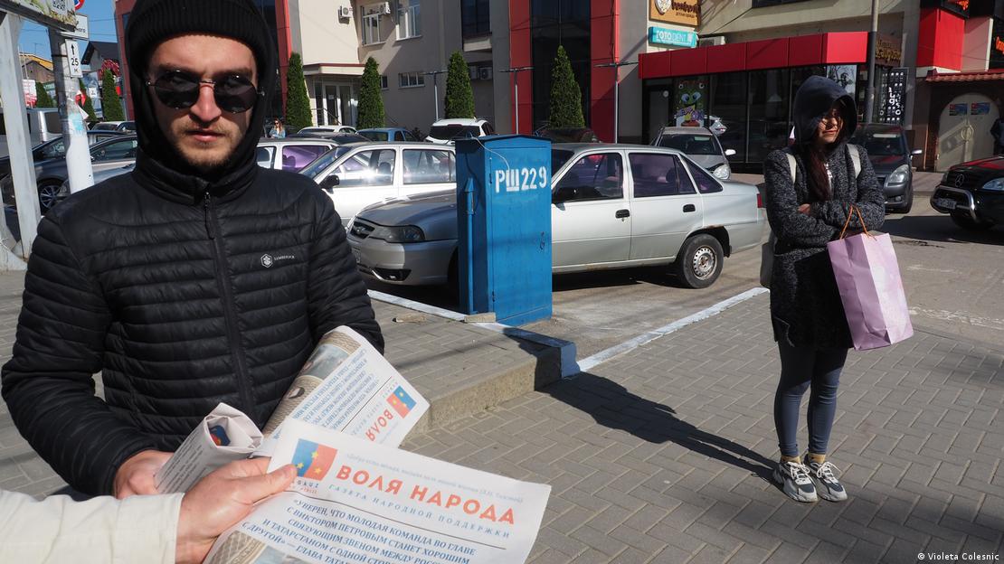 A young man in sunglasses handing out election leaflets