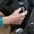 Emerytka używa kluczyka zapłonu, aby uruchomić samochód